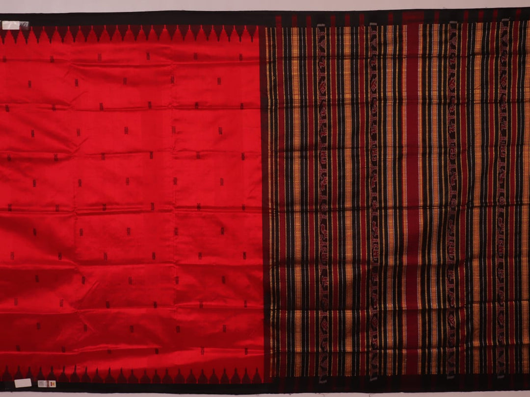 Textured close-up of red and black Sambalpuri Silk Saree fabric, highlighting the woven butta pattern.