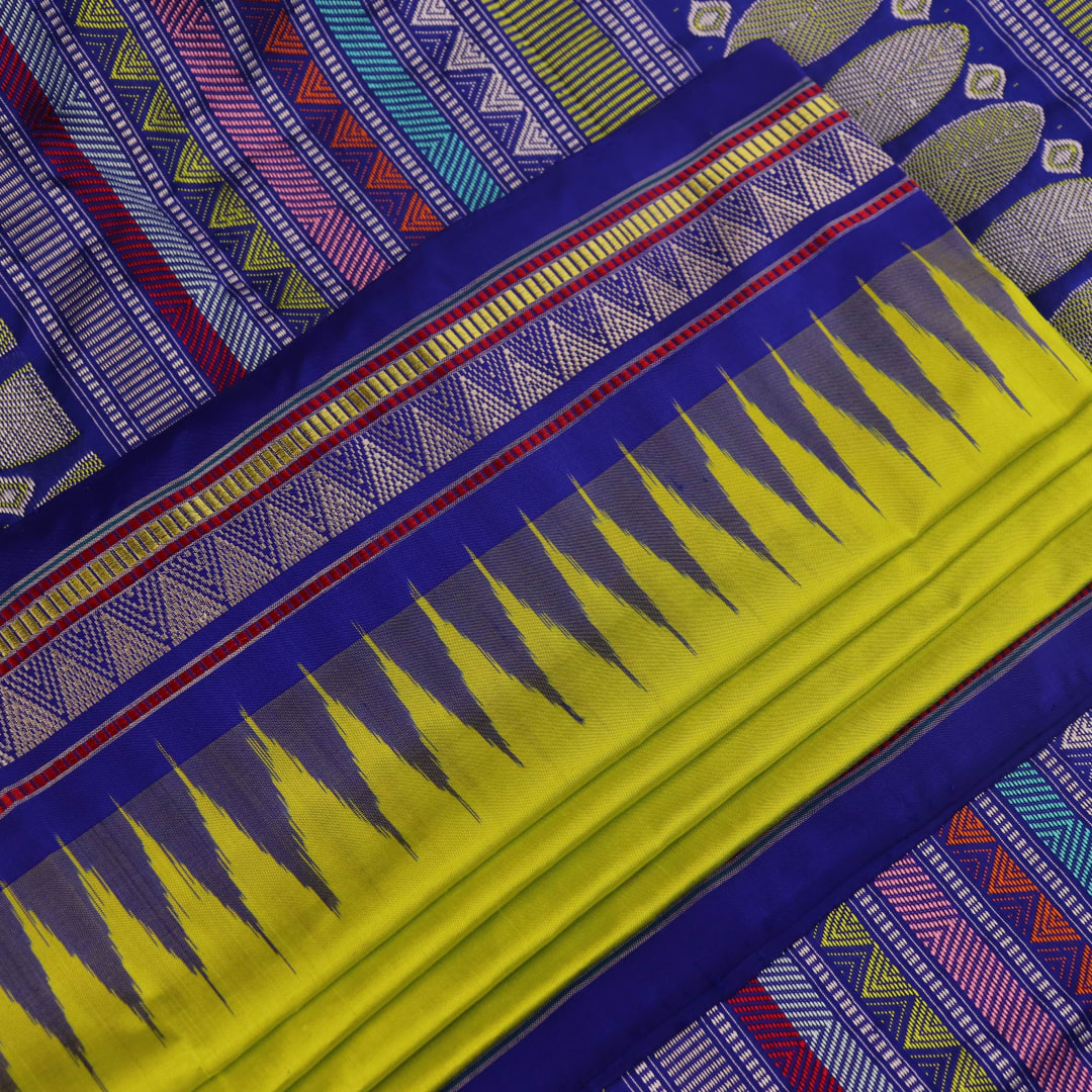 Close-up of green and blue Dongria silk saree fabric texture with butta pattern.