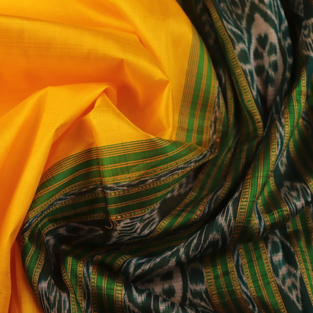 Yellow Khandua silk saree draped, showcasing its simple elegance and the plain body.