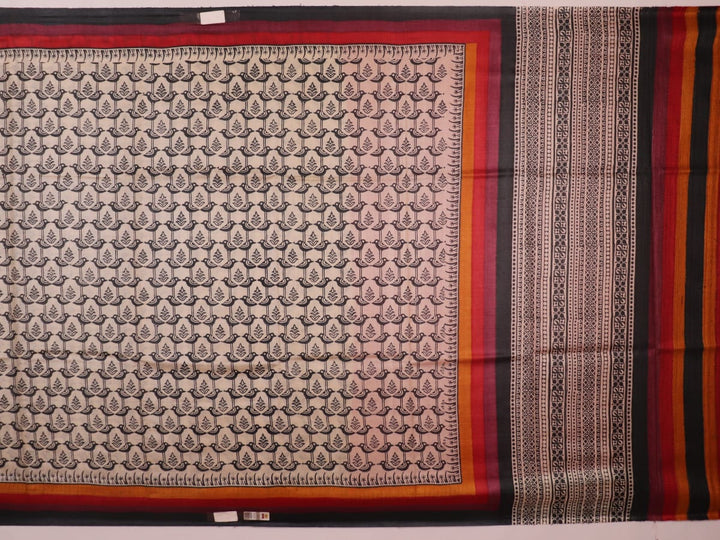 Close-up of off-white Tussar silk fabric, highlighting natural slubs and printed black pattern.