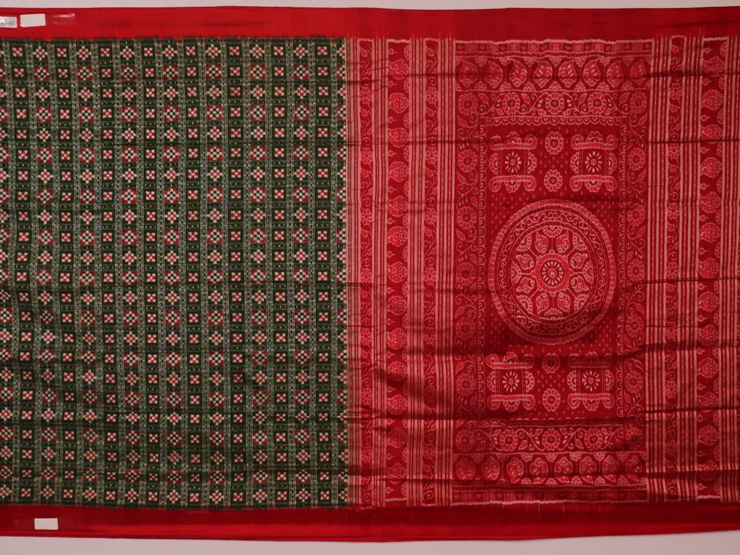 Close-up of green Sambalpuri silk saree fabric showing intricate woven motif texture and red thread details.