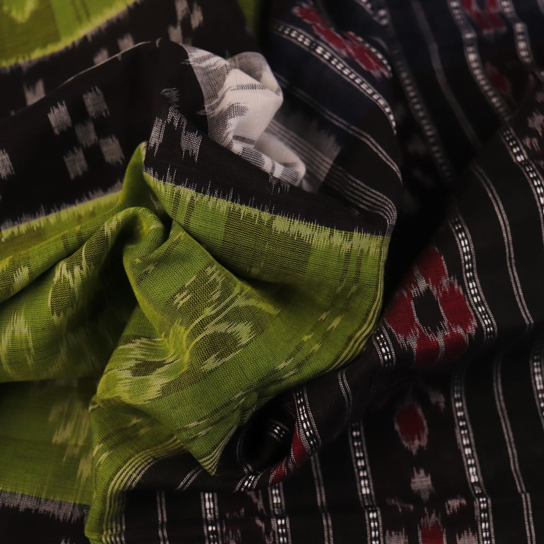 Styled green and black cotton Sambalpuri handloom saree with motifs, showcasing its elegant drape.