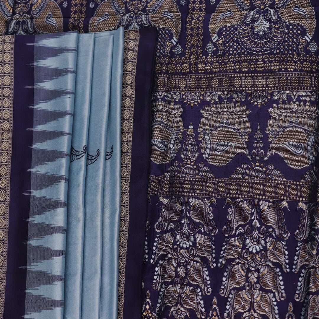 Close-up fabric texture of a blue Bomkai silk saree, revealing intricate butta pattern weave.