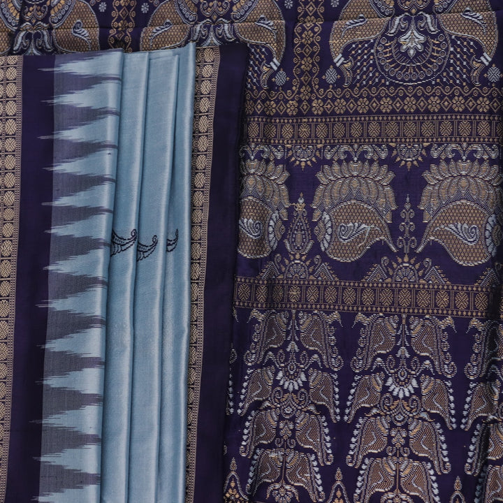 Close-up fabric texture of a blue Bomkai silk saree, revealing intricate butta pattern weave.