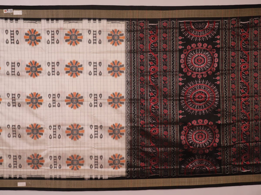 Close-up of handloom Sambalpuri silk saree fabric texture; white with subtle black motifs.