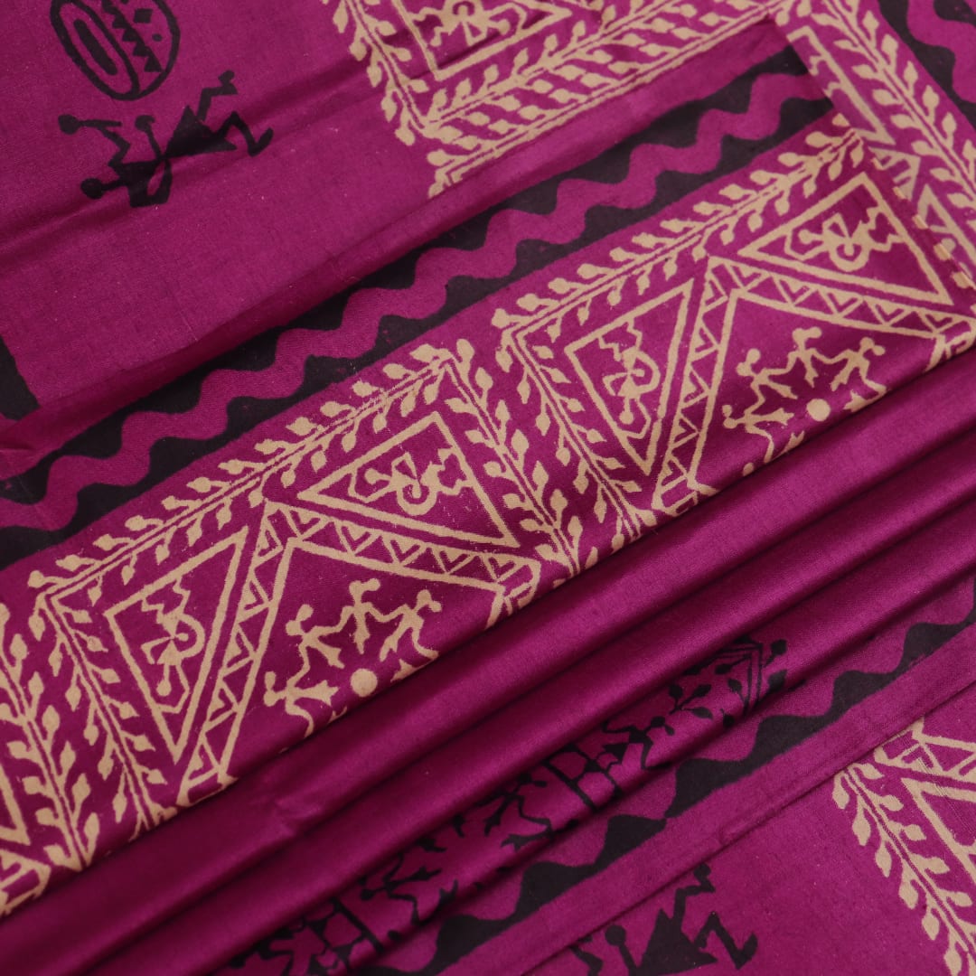 Close-up of magenta Tussar silk saree fabric, showing the printed pattern and natural slub texture.