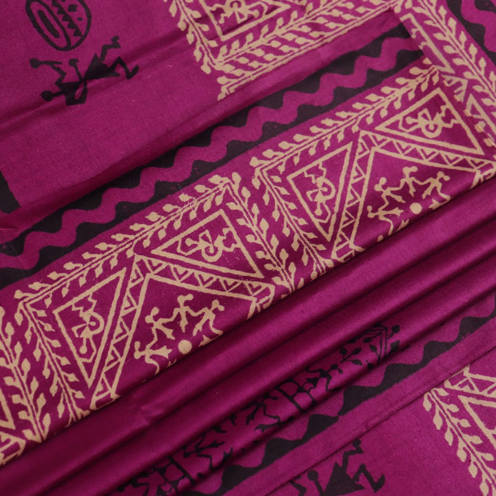 Close-up of magenta Tussar silk saree fabric, showing the printed pattern and natural slub texture.