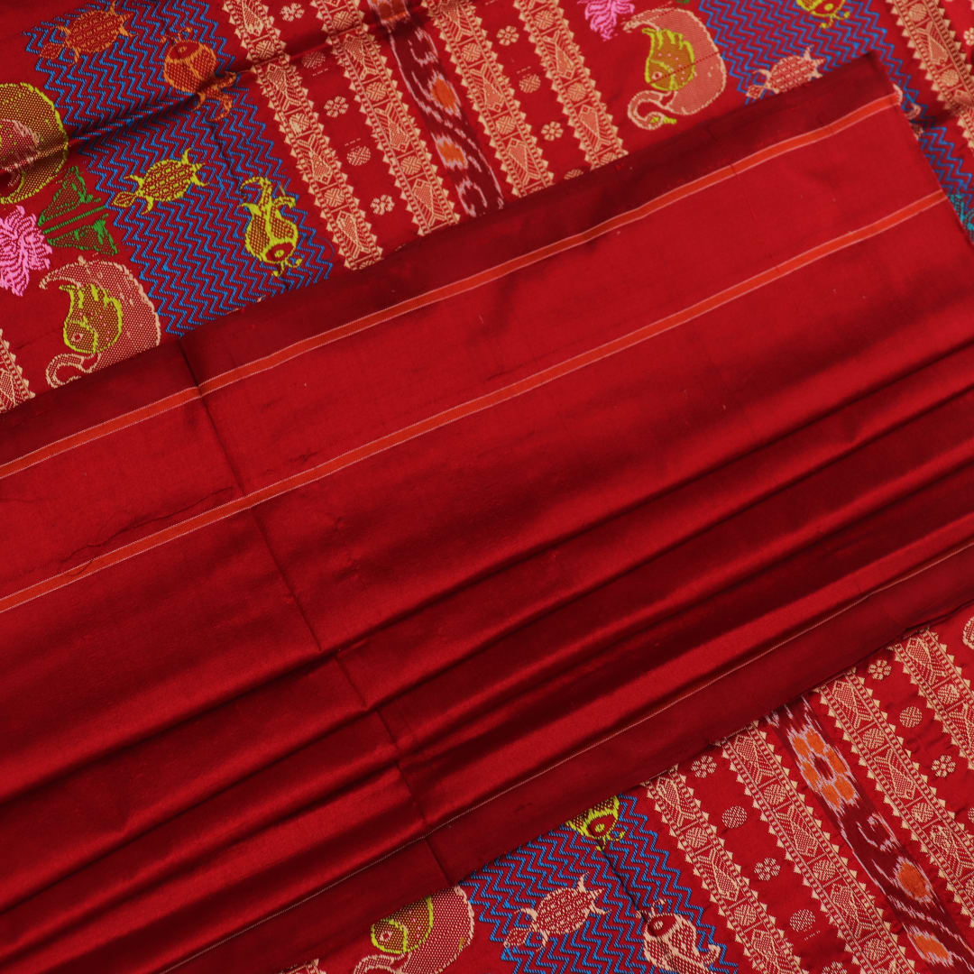 Close-up of maroon plain Sambalpuri silk saree fabric texture.
