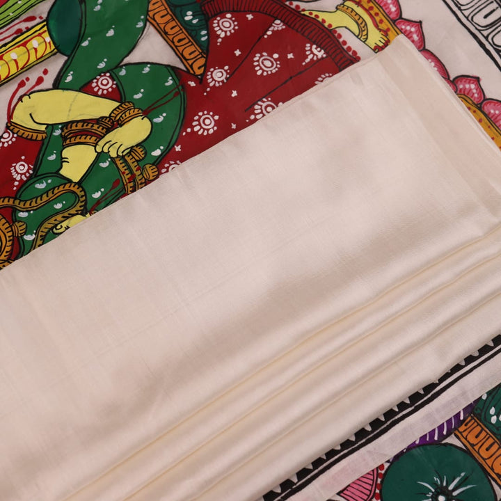 Close-up of handloom white silk Patachitra saree fabric showing texture and hand-painted details.