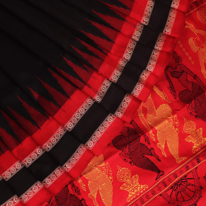 Close-up of Bomkai silk saree fabric texture in black and red, detailing the woven butta pattern.