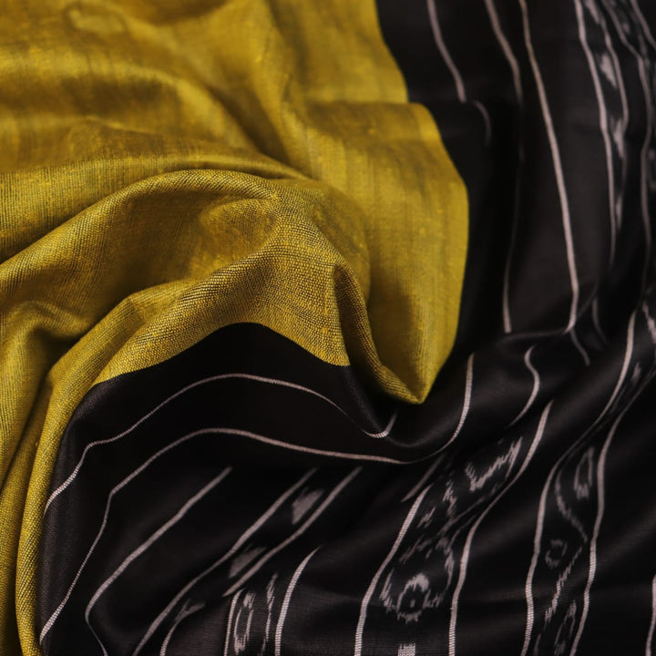 Close-up of the plain, slubby texture of a handwoven green and black Tussar silk saree.