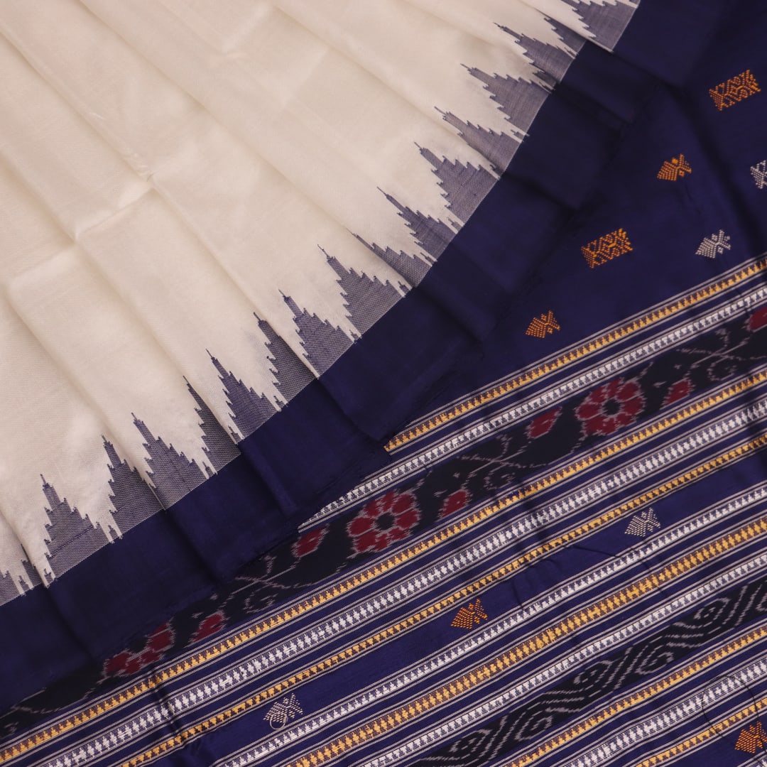 Close-up of white and blue Sambalpuri Silk Saree fabric texture, highlighting butta pattern.