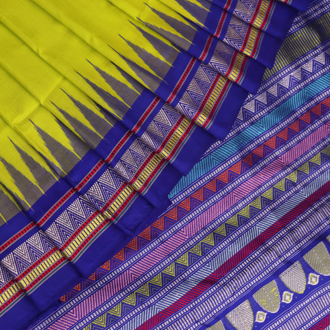 Close-up of green and blue Dongria silk saree fabric texture with butta pattern.