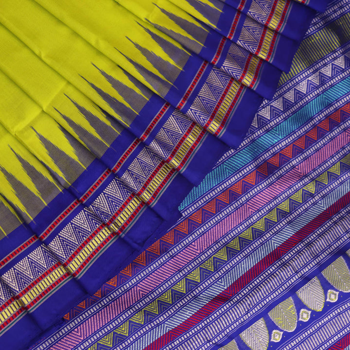 Close-up of green and blue Dongria silk saree fabric texture with butta pattern.