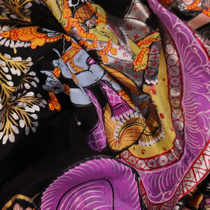 Close-up of black silk Patachitra saree fabric, showcasing hand-painted texture and detail.
