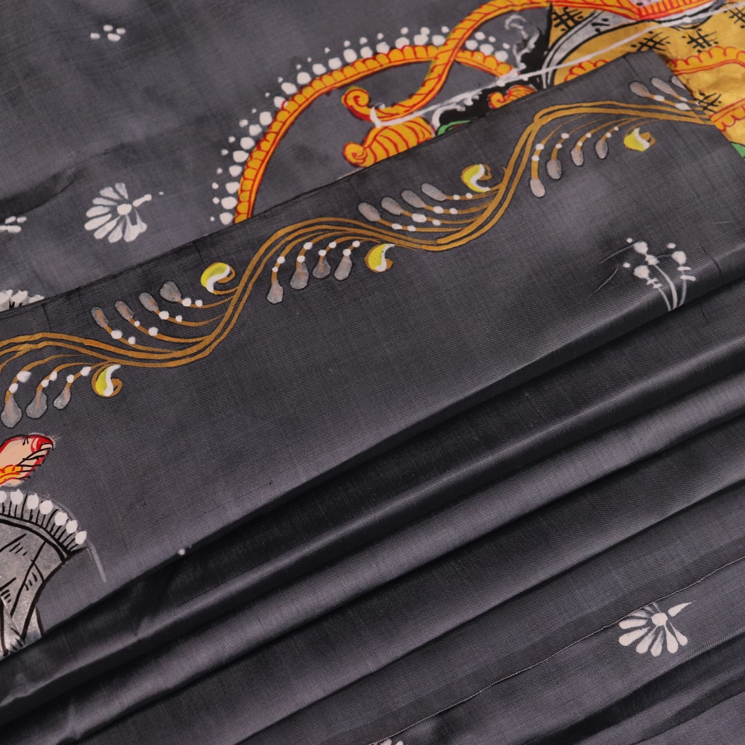 Close-up of handloom grey silk Patachitra saree fabric texture, revealing the intricate details of the hand-painted design.