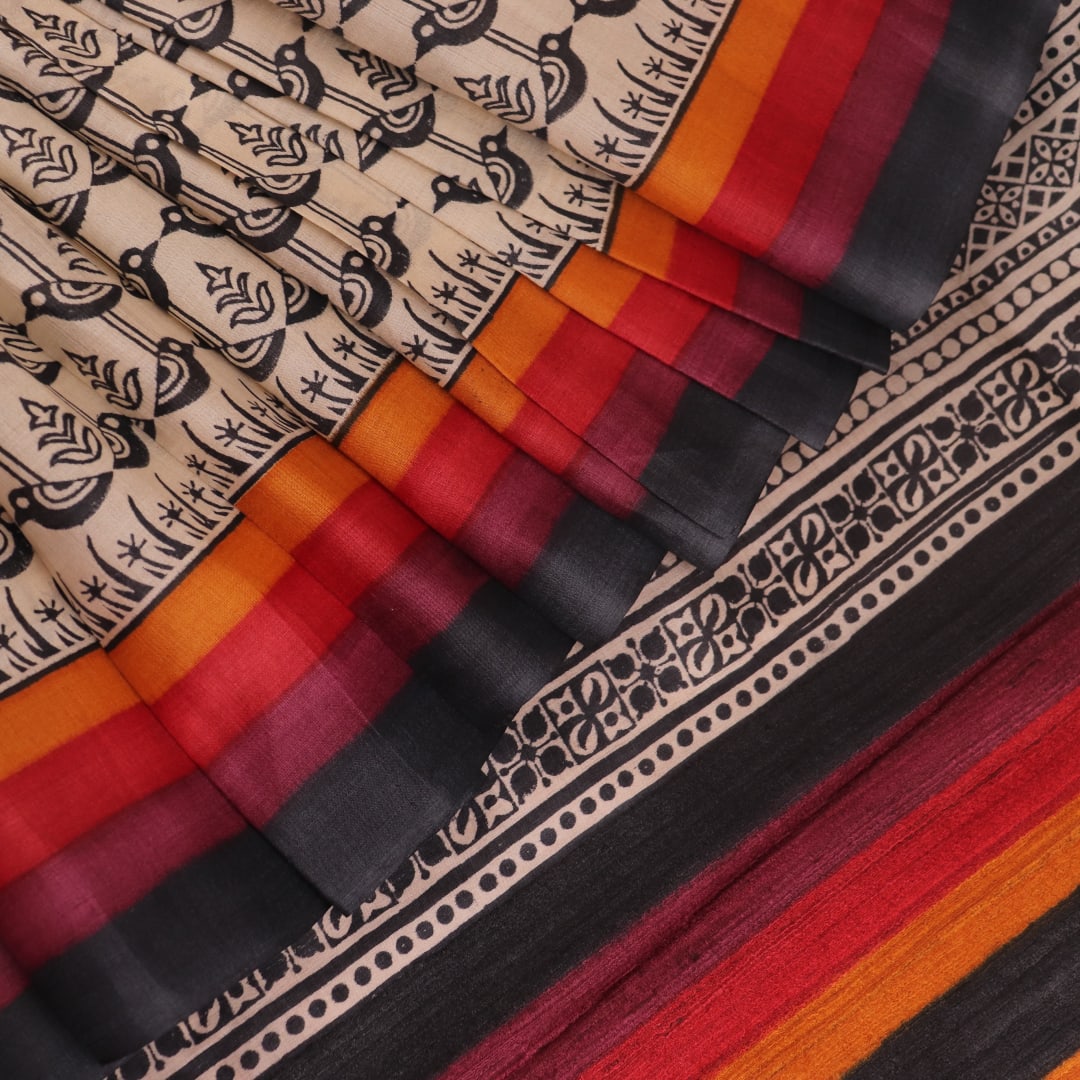 Close-up of off-white Tussar silk fabric, highlighting natural slubs and printed black pattern.