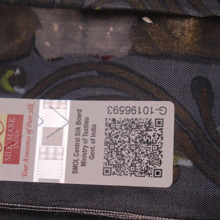 Close-up of handloom grey silk Patachitra saree fabric texture, revealing the intricate details of the hand-painted design.