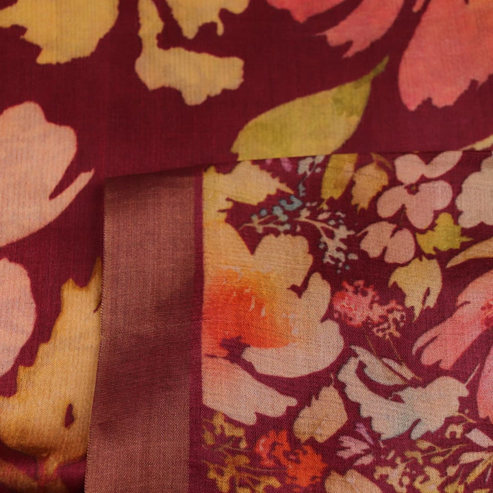 Close-up of maroon Tussar silk saree fabric, emphasizing its distinct texture and printed pattern.