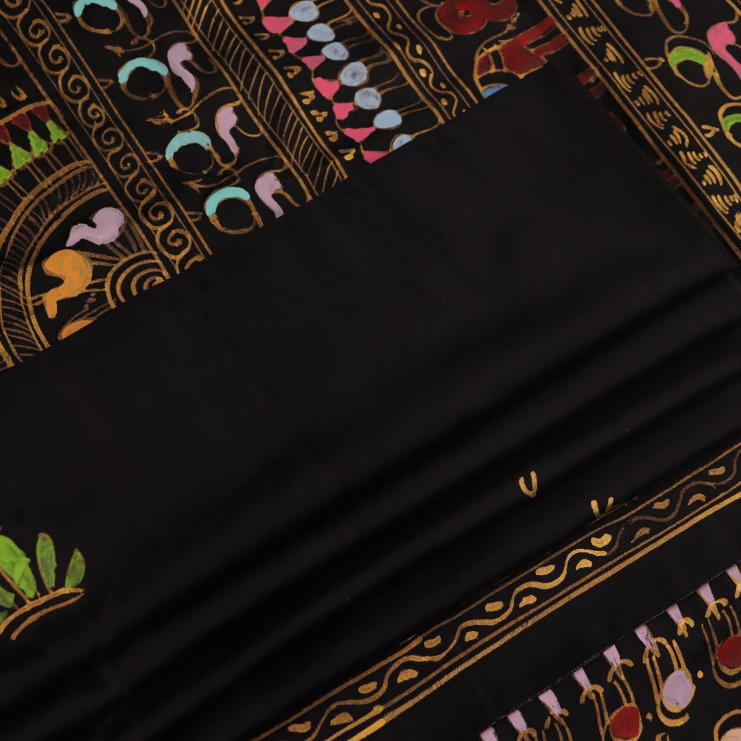 Close-up of the black silk Patachitra saree, showcasing the hand-painted fabric texture.