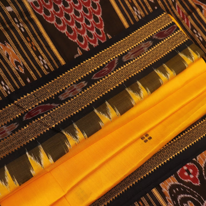 Model showcasing yellow Khandua silk saree with black butta pattern.
