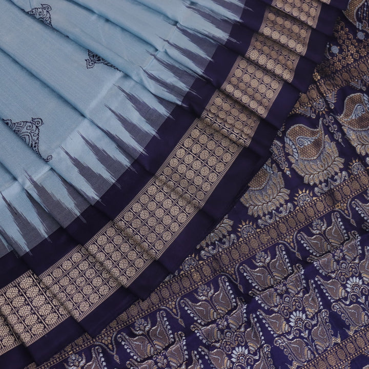 Close-up fabric texture of a blue Bomkai silk saree, revealing intricate butta pattern weave.