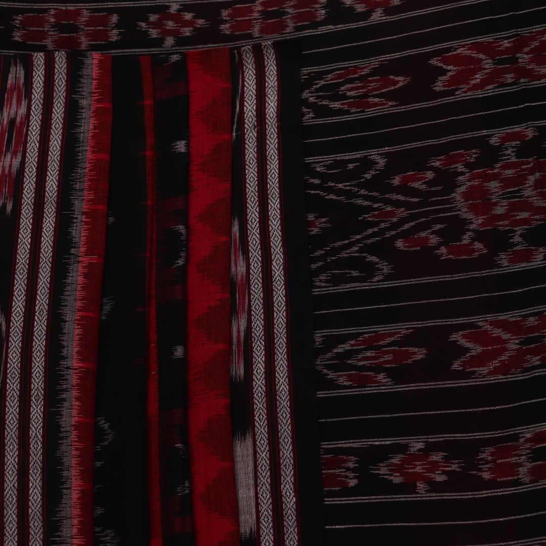 Red and black Sambalpuri cotton saree draped, showcasing overall styling and motifs.