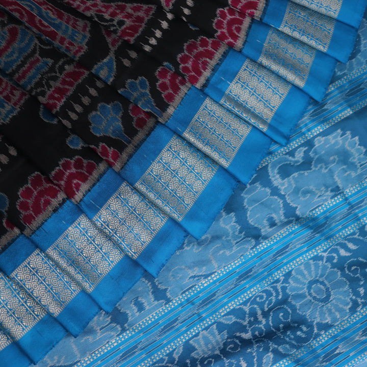 Close-up of multi-color Sambalpuri silk saree fabric showing texture and woven motifs; secondary color blue visible.