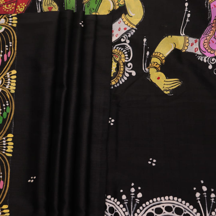 Close-up of black silk Patachitra saree fabric texture showing hand-painted details.