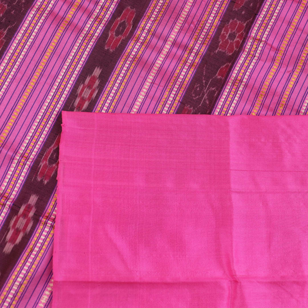 Close-up of plain green and pink Sambalpuri silk saree fabric texture.