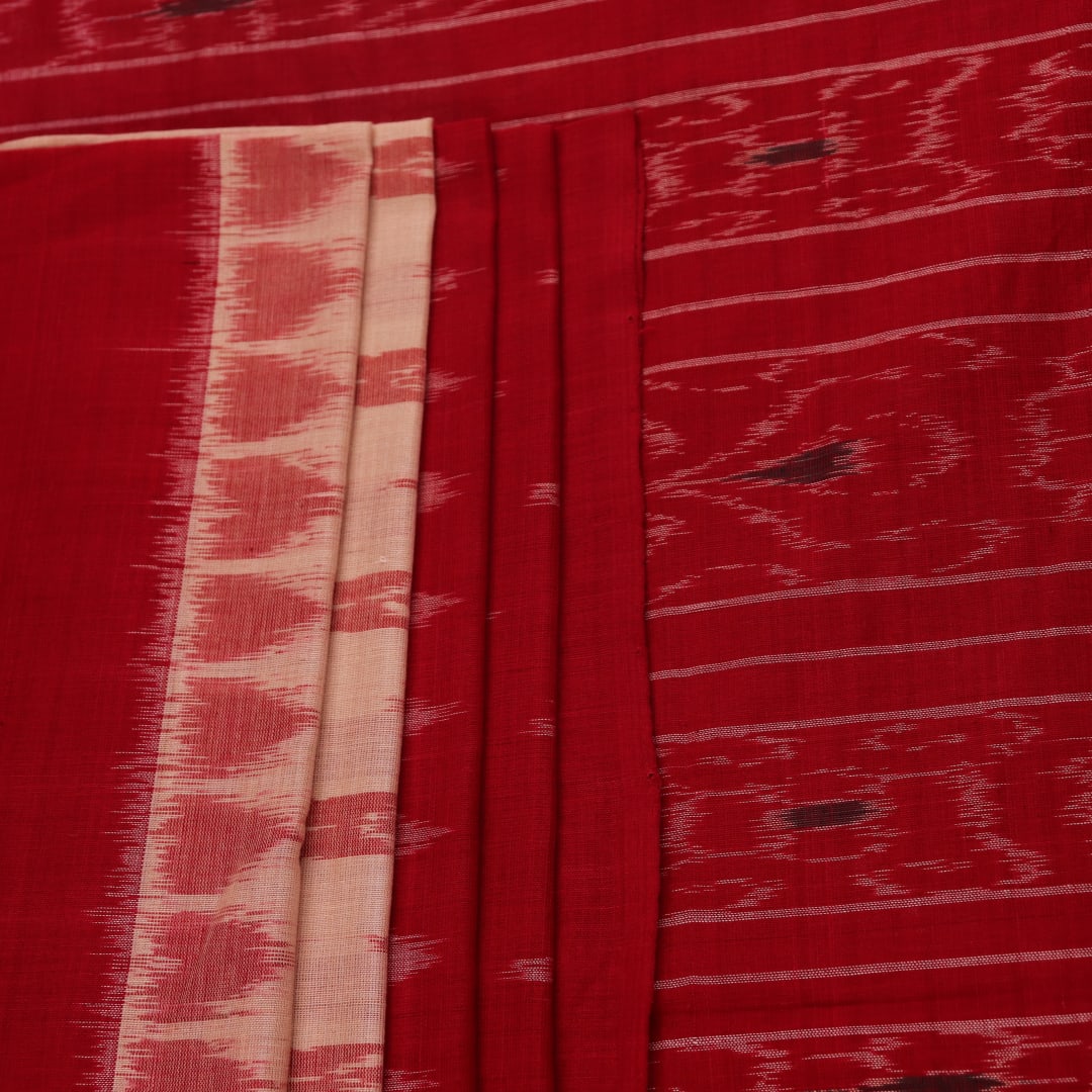 Cream and red Sambalpuri cotton saree with motifs elegantly draped on a person.