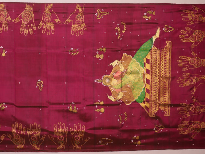 Close-up of magenta Patachitra silk saree fabric texture showing handloom weave and paint details.