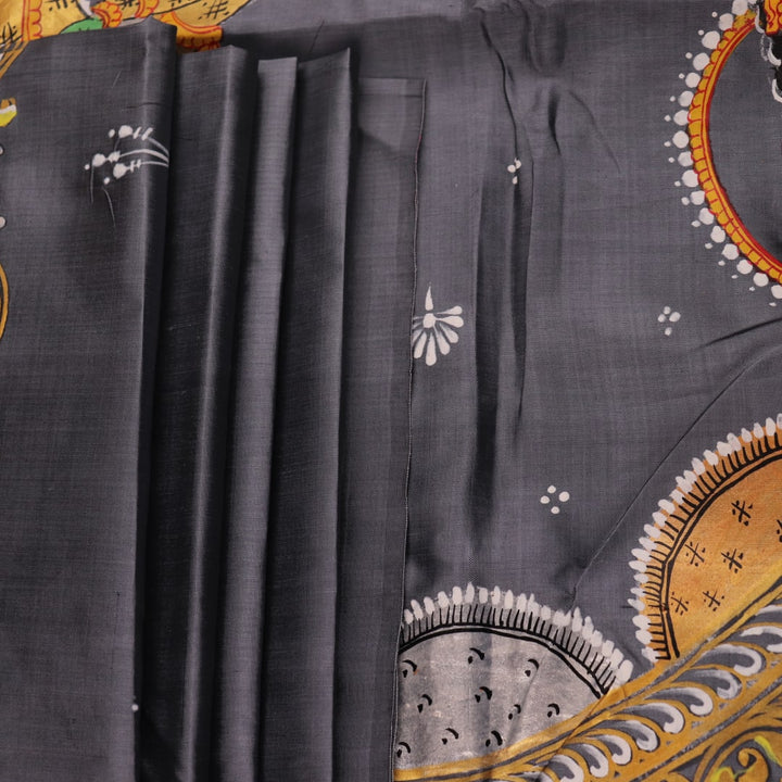 Close-up of handloom grey silk Patachitra saree fabric texture, revealing the intricate details of the hand-painted design.