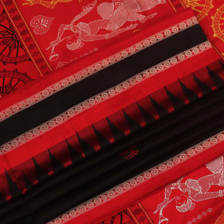 Close-up of Bomkai silk saree fabric texture in black and red, detailing the woven butta pattern.