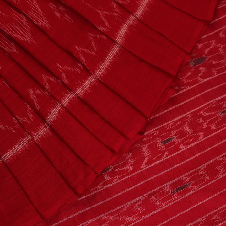 Cream and red Sambalpuri cotton saree with motifs elegantly draped on a person.