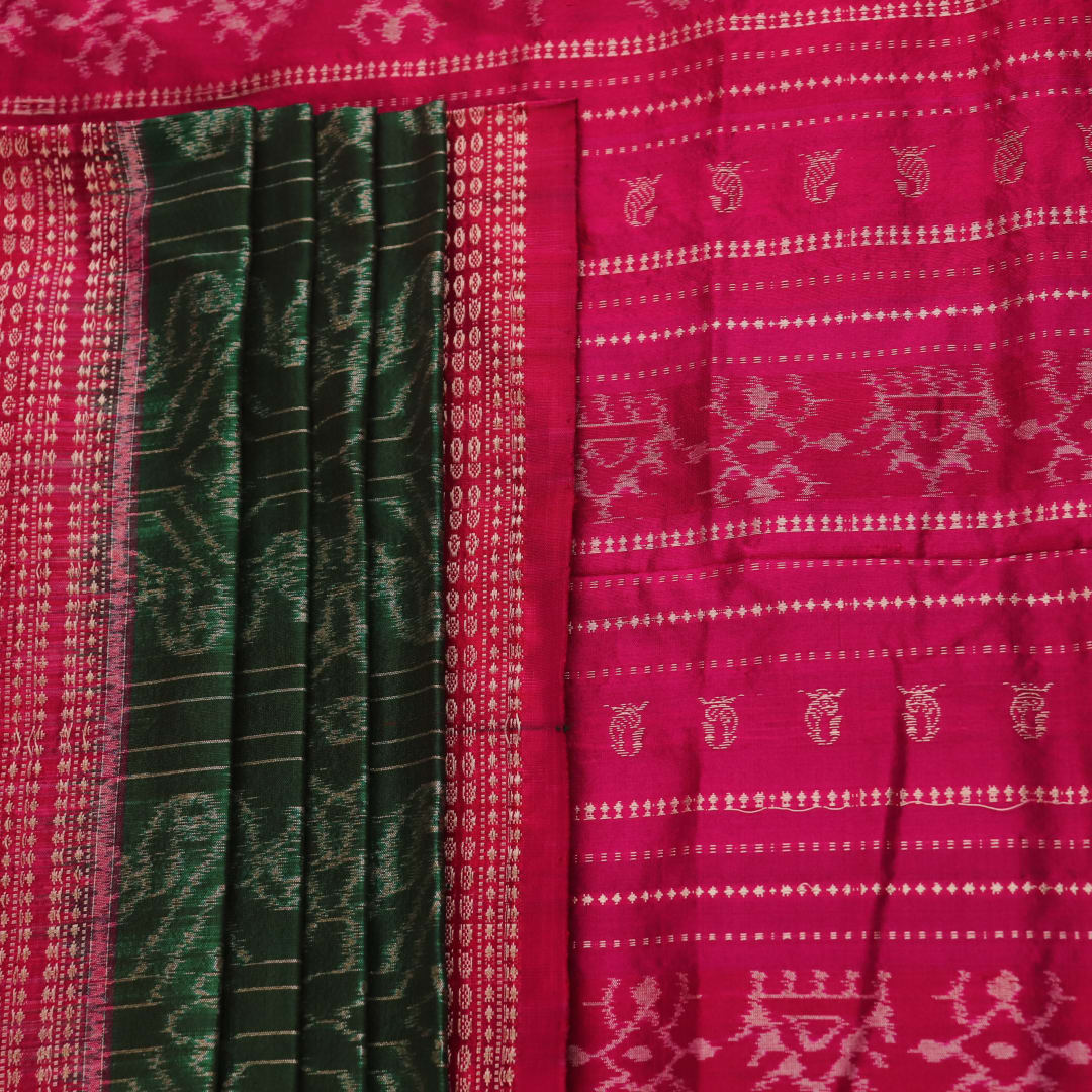 Close-up of textured green Sambalpuri silk saree fabric with magenta motifs.