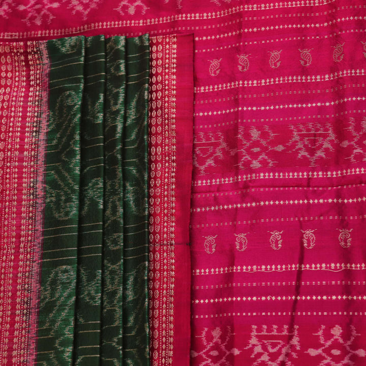 Close-up of textured green Sambalpuri silk saree fabric with magenta motifs.