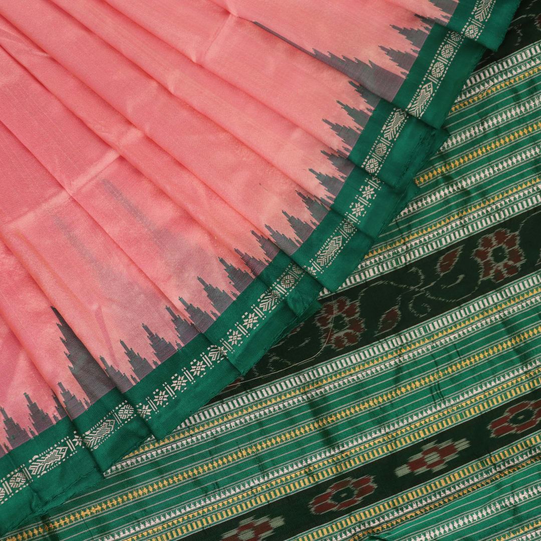 Close-up of the plain woven silk texture of a pink and green Sambalpuri saree.