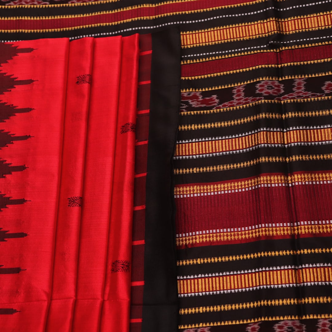 Textured close-up of red and black Sambalpuri Silk Saree fabric, highlighting the woven butta pattern.