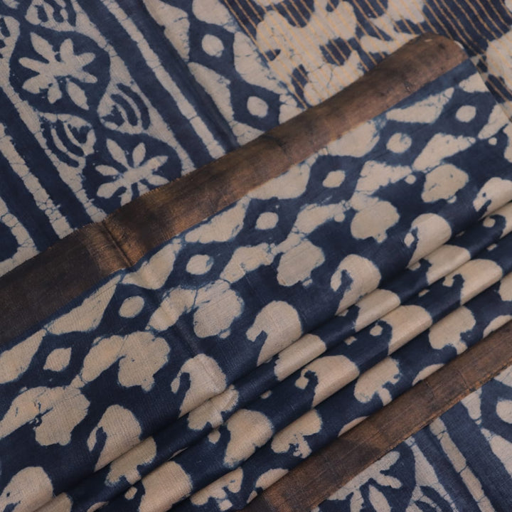 Close-up of blue printed Tussar silk saree fabric texture.