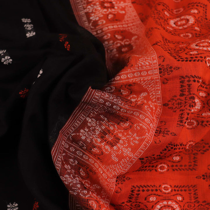 Full view of a black and orange Bomkai cotton handloom saree with butta pattern.