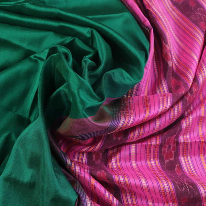 Close-up of plain green and pink Sambalpuri silk saree fabric texture.