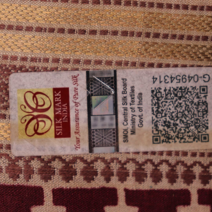 Close-up of maroon Tussar silk saree fabric, showing natural slub texture and printed pattern.