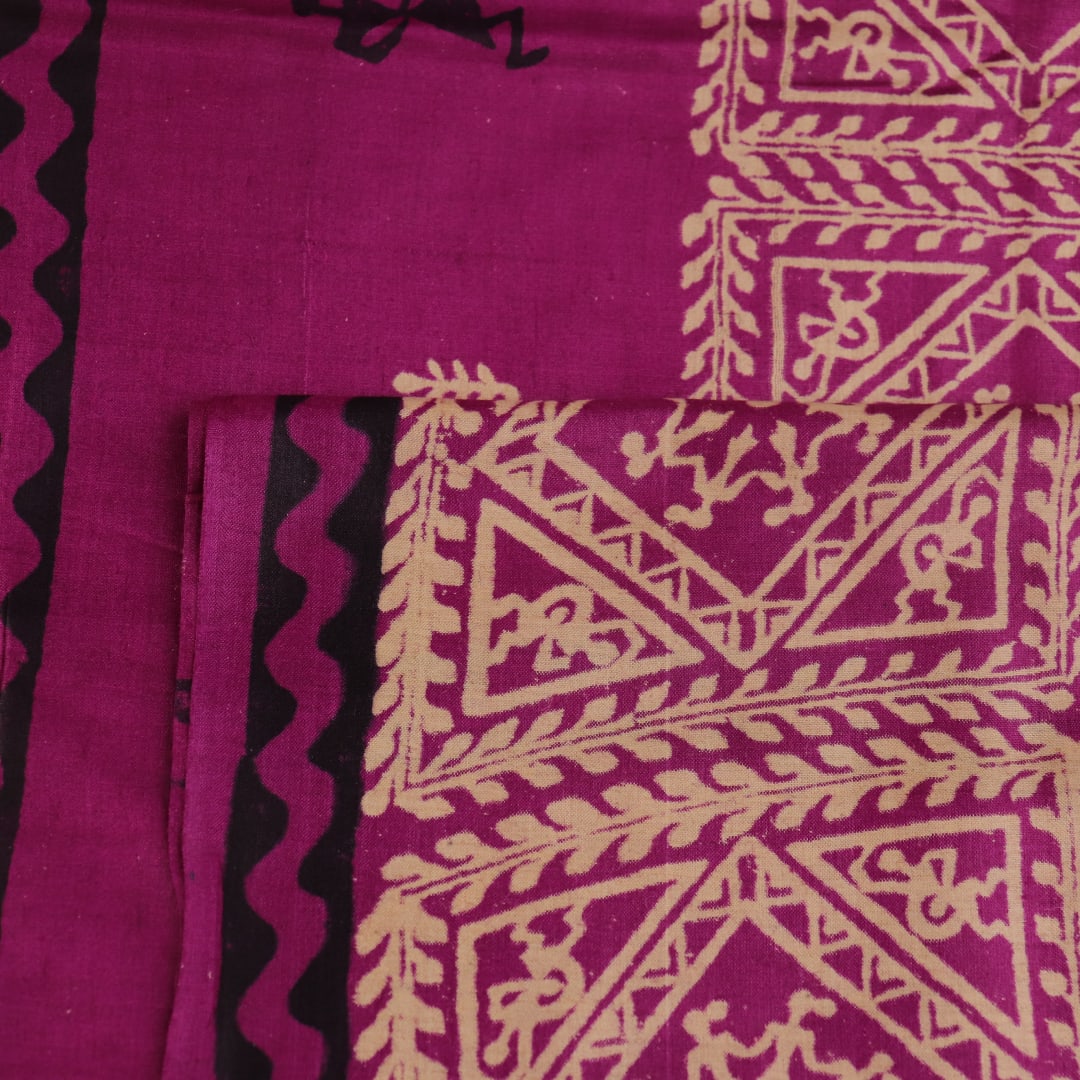 Close-up of magenta Tussar silk saree fabric, showing the printed pattern and natural slub texture.