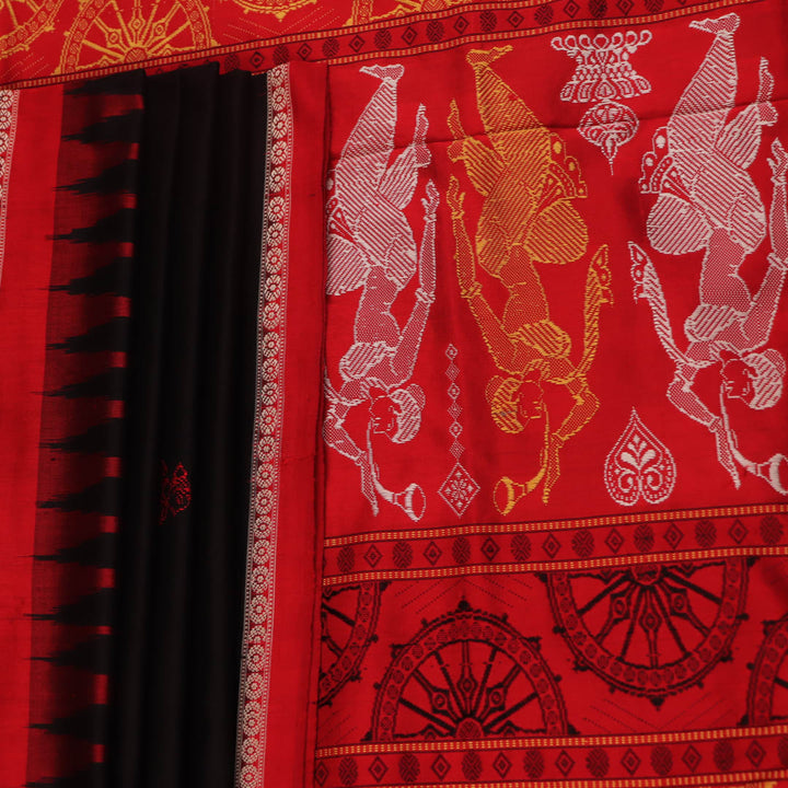 Close-up of Bomkai silk saree fabric texture in black and red, detailing the woven butta pattern.