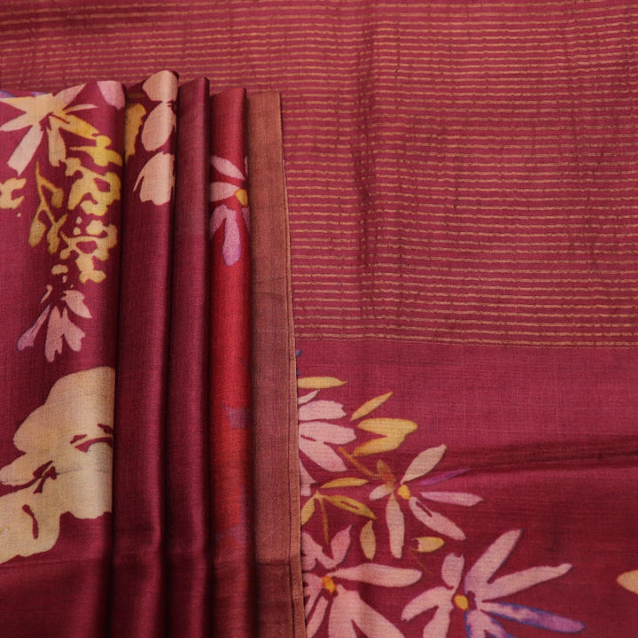 Close-up of maroon Tussar silk saree fabric, emphasizing its distinct texture and printed pattern.