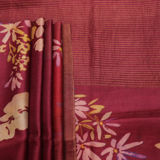Close-up of maroon Tussar silk saree fabric, emphasizing its distinct texture and printed pattern.