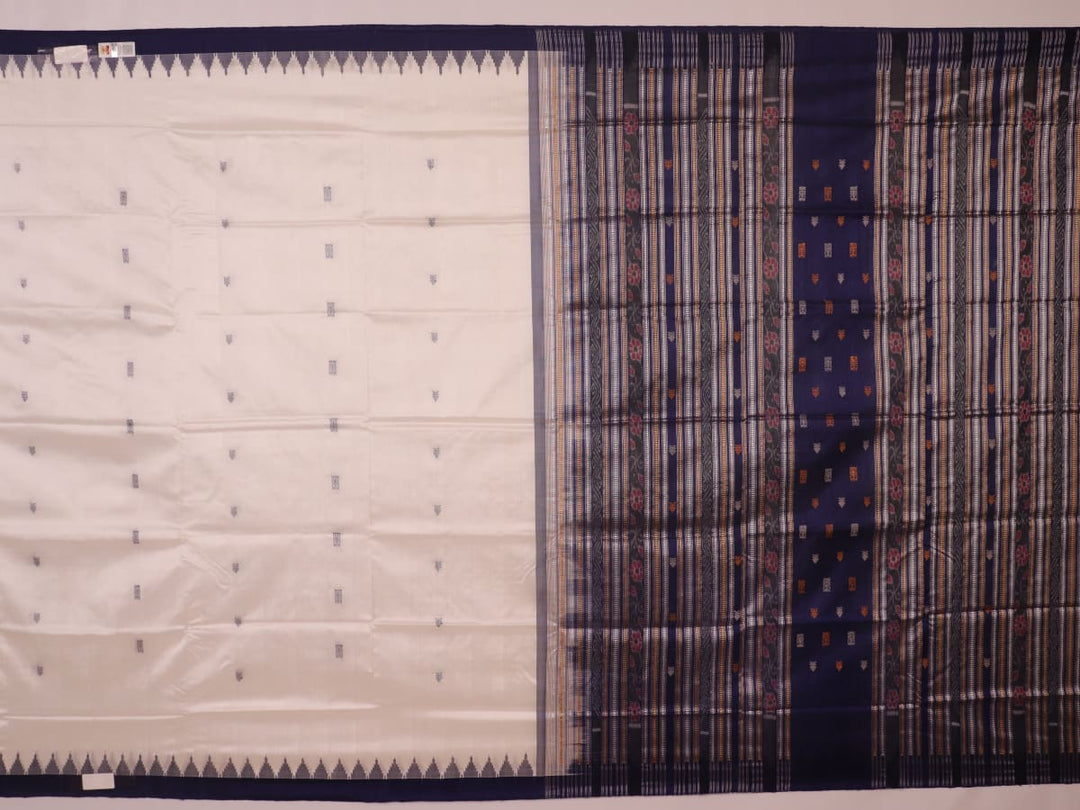 Close-up of white and blue Sambalpuri Silk Saree fabric texture, highlighting butta pattern.