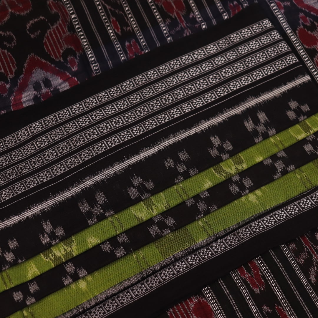 Styled green and black cotton Sambalpuri handloom saree with motifs, showcasing its elegant drape.