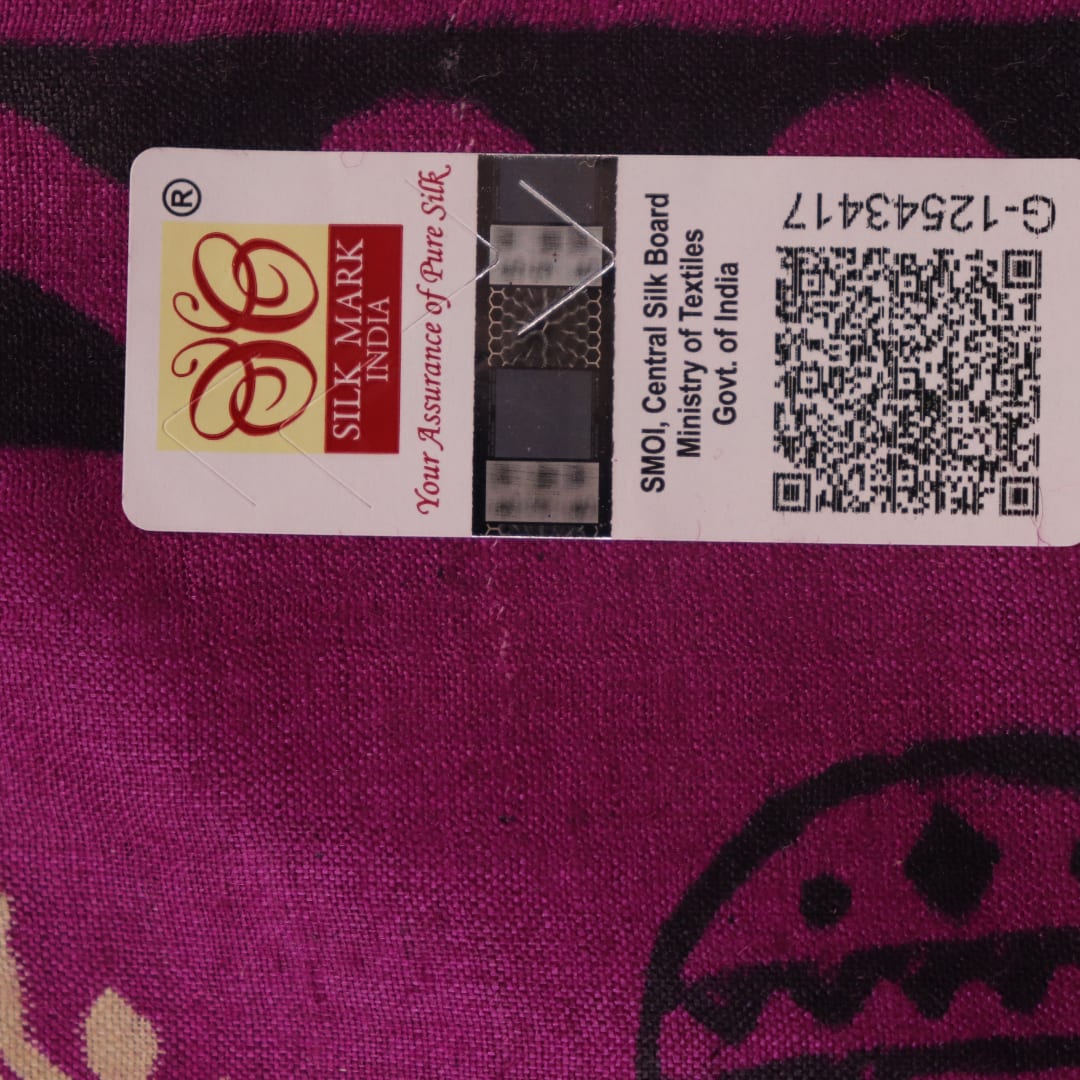 Close-up of magenta Tussar silk saree fabric, showing the printed pattern and natural slub texture.
